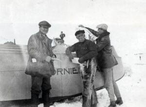 Tre menn foran en flybåt
