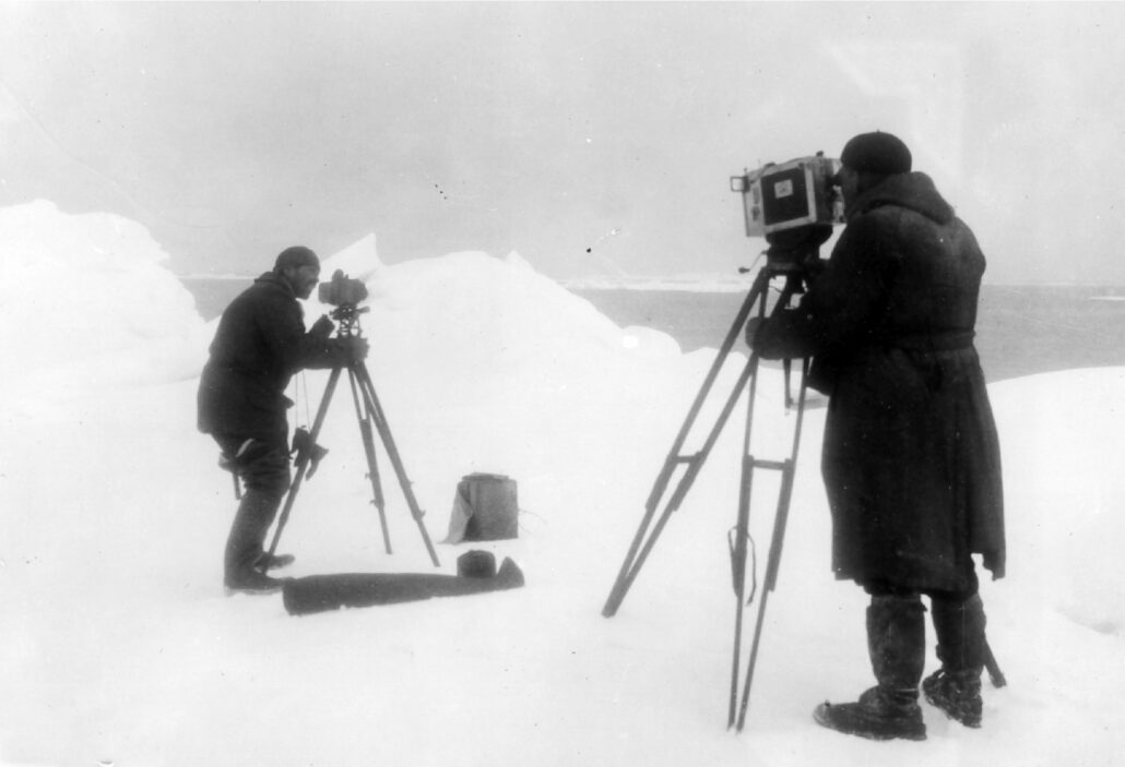 To menn har apparater på tripod på isgrunn