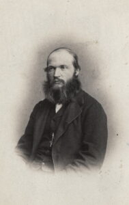 Portrett av mann med mørkt skjegg og penklær