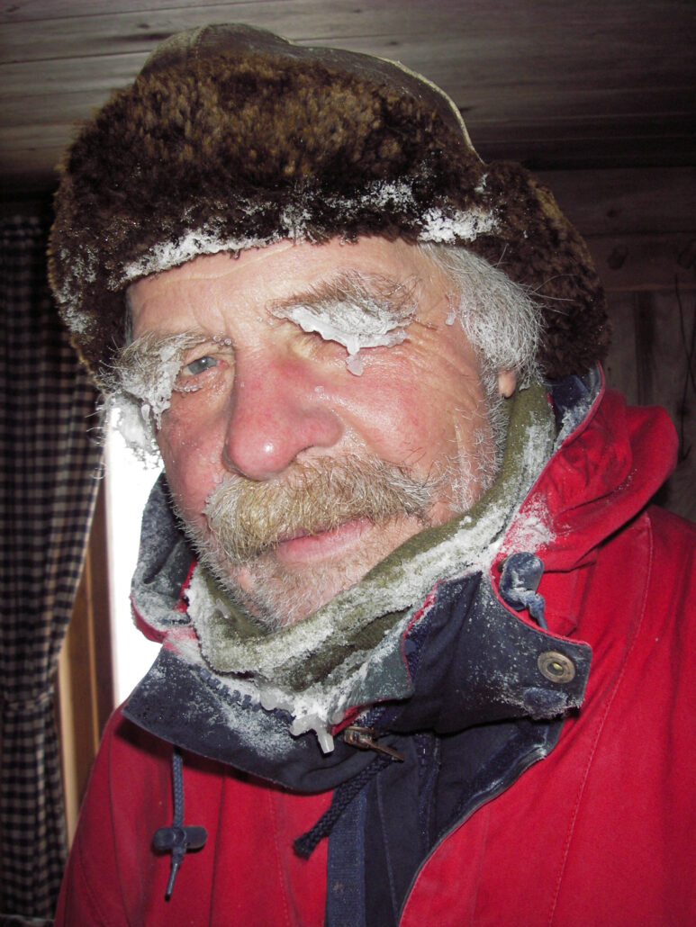 Mann i ytterklær og lue har rimfrost på øyenbryn som henger tungt over øynene