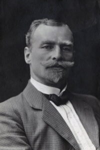 Portrett av mann i rutete dress med bart og skjegg