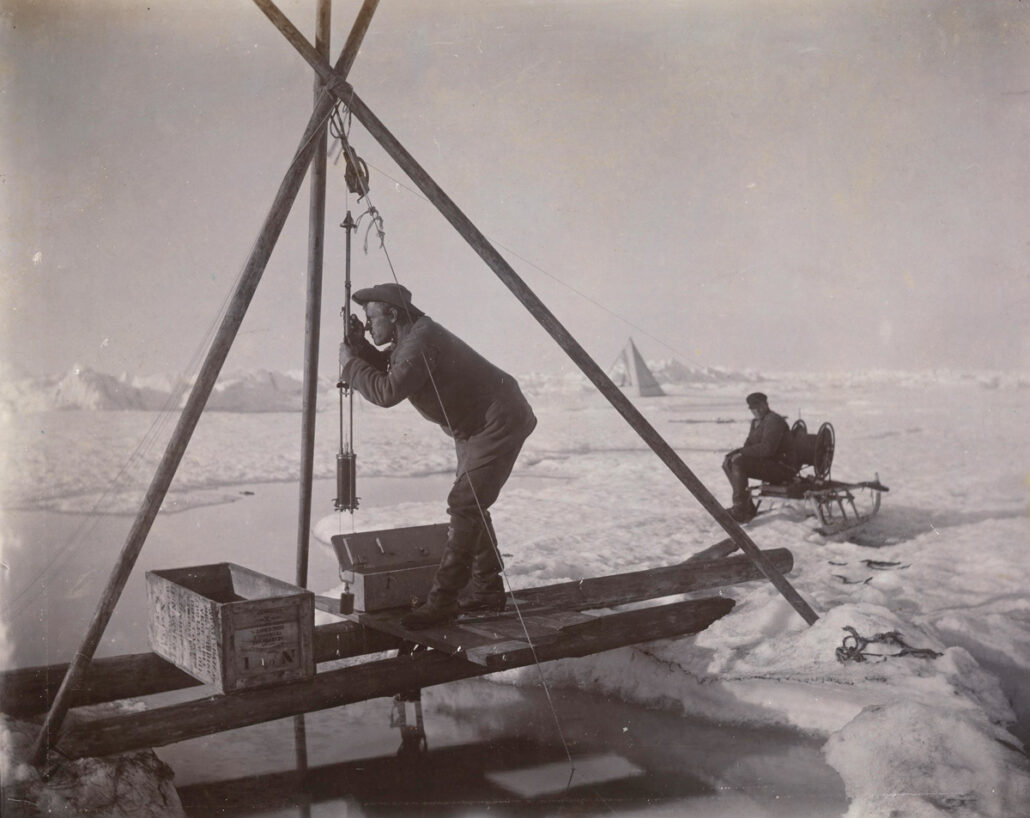 Mann foretar målinger med en tripod som står over et vannhull
