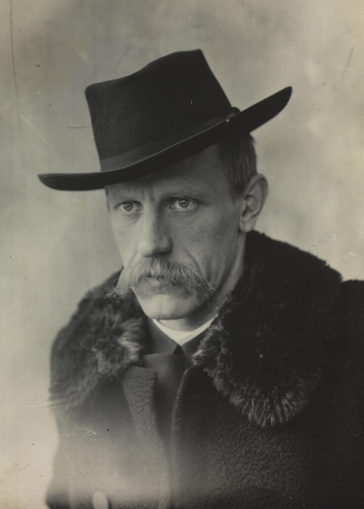 Portrett av mann i hatt og ulljakke med pelskrage