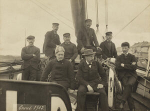 Gruppebilde av åtte menn om bord en båt