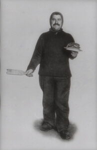 Mann står med stabel pannekaker i hånda