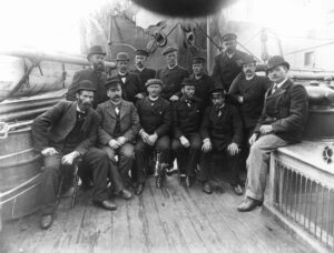 En gruppe menn poserer sittende på et båtdekk